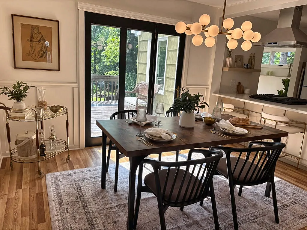 Staged dining room with a walnut table, black spindle chairs, and a globe chandelier