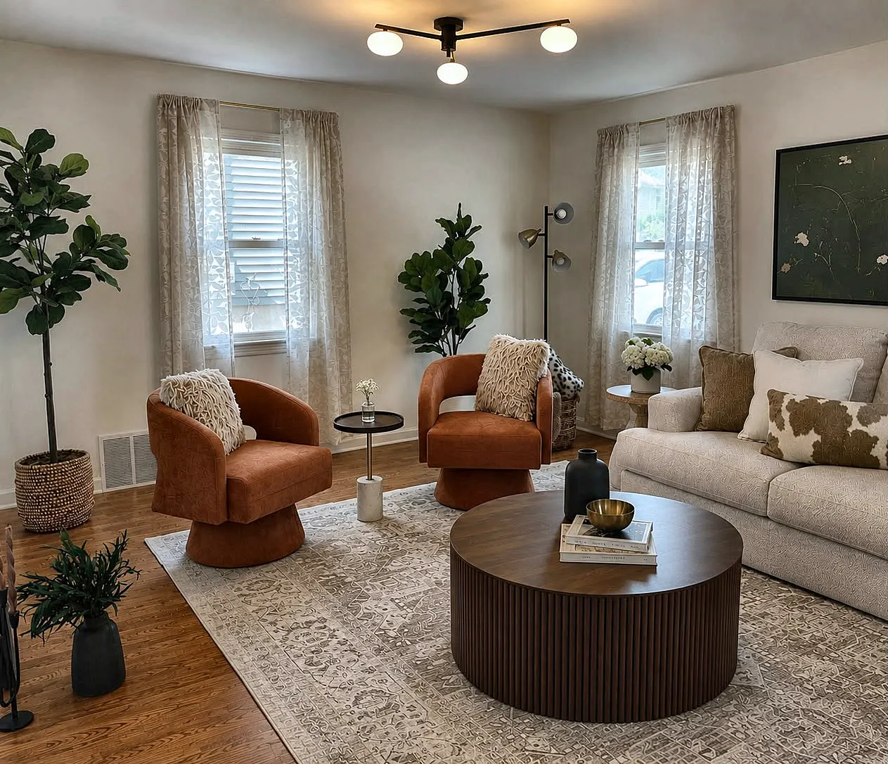 Living room staged with two rust swivel chairs, a fluted walnut coffee table, and a cream sofa