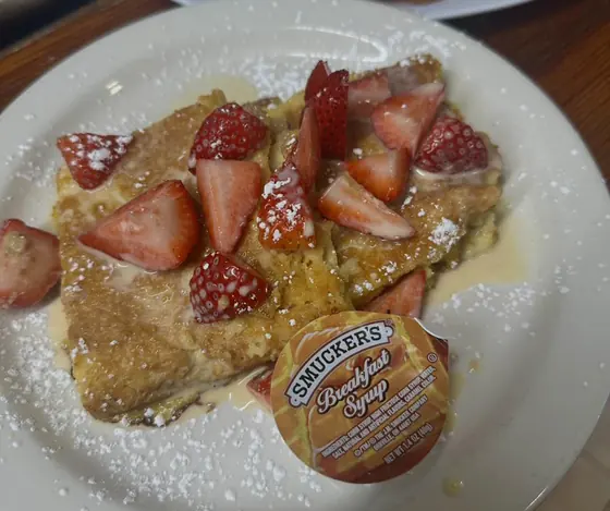 French toast topped with fresh strawberries and powdered sugar